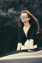 Young fashion woman in sunglasses leaning on her car Royalty Free Stock Photo