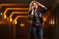 Young fashion woman in leather jacket calling on mobile phone Royalty Free Stock Photo