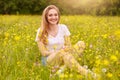 Young fashion woman posing in summer meadow. Trendy girl at nature landscape background. Happy smiling female sitting among yellow Royalty Free Stock Photo