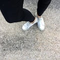 Young Fashion Woman`s Legs with Sneakers, White Shoes on Floor Background