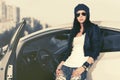Young fashion woman in sunglasses leaning on her car Royalty Free Stock Photo