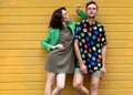 Young fashionable couple on yellow background