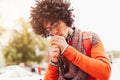 Young fashionable dressed curly black African American A student with a backpack standing against the background of glass walls