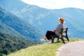 Young fashionable dressed female in straw hat sitting on a bench enjoying Santa Maddalena village view and stunning picturesque Royalty Free Stock Photo