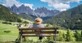 Young fashionable dressed female in straw hat sitting on a bench enjoying Santa Maddalena village view and stunning picturesque Royalty Free Stock Photo