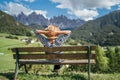 Young fashionable dressed female in straw hat sitting on bench with hands behind a head enjoying Santa Maddalena village and Royalty Free Stock Photo