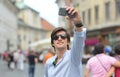 Young fashionable hipster Hispanic man with sunglasses taking a selfie