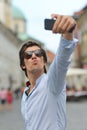 Young fashionable hipster Hispanic man with sunglasses taking a selfie