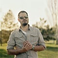 Young fashionable man with sunglasses outddoors. Analog film portrait shot on square medium format ratio Royalty Free Stock Photo