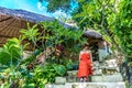 Young fashionable woman in red dress in a tropical garden. Portrait of happy woman relaxing on Bali island, Indonesia. Royalty Free Stock Photo