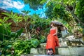 Young fashionable woman in red dress in a tropical garden. Portrait of happy woman relaxing on Bali island, Indonesia. Royalty Free Stock Photo