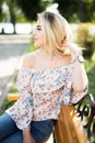 Young woman uses smartphone sitting on bench in the Park. Royalty Free Stock Photo