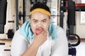 Young fat man eating an apple on fitness machine Royalty Free Stock Photo