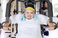 Young fat man exercising with a fitness machine Royalty Free Stock Photo