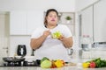 Young fat woman eats tasty salad in the kitchen Royalty Free Stock Photo