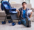 Young father assembling baby pram at home