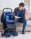 Young father assembling baby pram at home