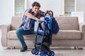 The young father assembling baby pram at home