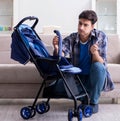 Young father assembling baby pram at home