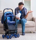 Young father assembling baby pram at home