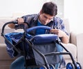 Young father assembling baby pram at home