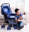 Young father assembling baby pram at home