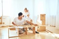 Father assembling furniture in living room of new apartment, mother with son and pile of moving boxes on background Royalty Free Stock Photo