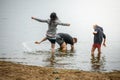 A young father with a baby on his shoulders happy walks along the beach and the family in the background. Royalty Free Stock Photo