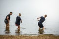 A young father with a baby on his shoulders happy walks along the beach and the family in the background. Royalty Free Stock Photo