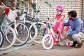 Young father buying new bicycle for little girl in bike shop