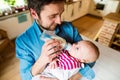 Young father carrying and feeding his newborn baby son Royalty Free Stock Photo