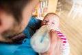 Young father carrying and feeding his newborn baby son Royalty Free Stock Photo