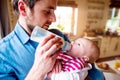 Young father carrying and feeding his newborn baby son Royalty Free Stock Photo