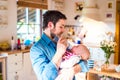 Young father carrying and feeding his newborn baby son Royalty Free Stock Photo