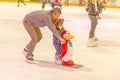 A young father with a child skating on the rink