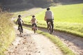 Young father with children ride bikes in park