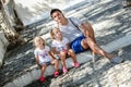 Young father and cute daughters sitting on street Royalty Free Stock Photo