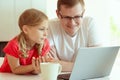 Young father with cute doughter learning online at homeschooling