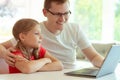 Young father with cute doughter learning online at homeschooling