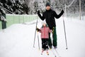 Young father and daughter do Nordic skiing