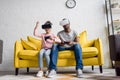 young father and daughter in vr headsets playing video games on couch Royalty Free Stock Photo