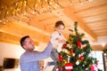 Young father with daugter decorating Christmas tree together. Royalty Free Stock Photo