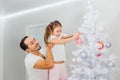 Young father with daugter decorating Christmas tree together Royalty Free Stock Photo