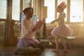 A young father enjoying a ballet training at home with his little ballerina. Family, ballet, training