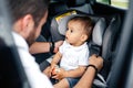 Young father fastening baby in car child seat Royalty Free Stock Photo