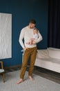 Young father gently holds a cute baby in his arms. Portrait of a father and a small child of a son Royalty Free Stock Photo