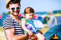 Young father with his baby daughter between tents, summer Royalty Free Stock Photo