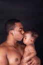 Young father and his baby kissing his child both african american in an intimate and happy moment Royalty Free Stock Photo