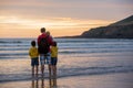 Young father with his beautiful children, enjoying the sunset over the ocean on a low tide in Devon Royalty Free Stock Photo
