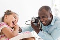 Young father with his cute little daughter taking pictures of each other on an old vintage camera Royalty Free Stock Photo